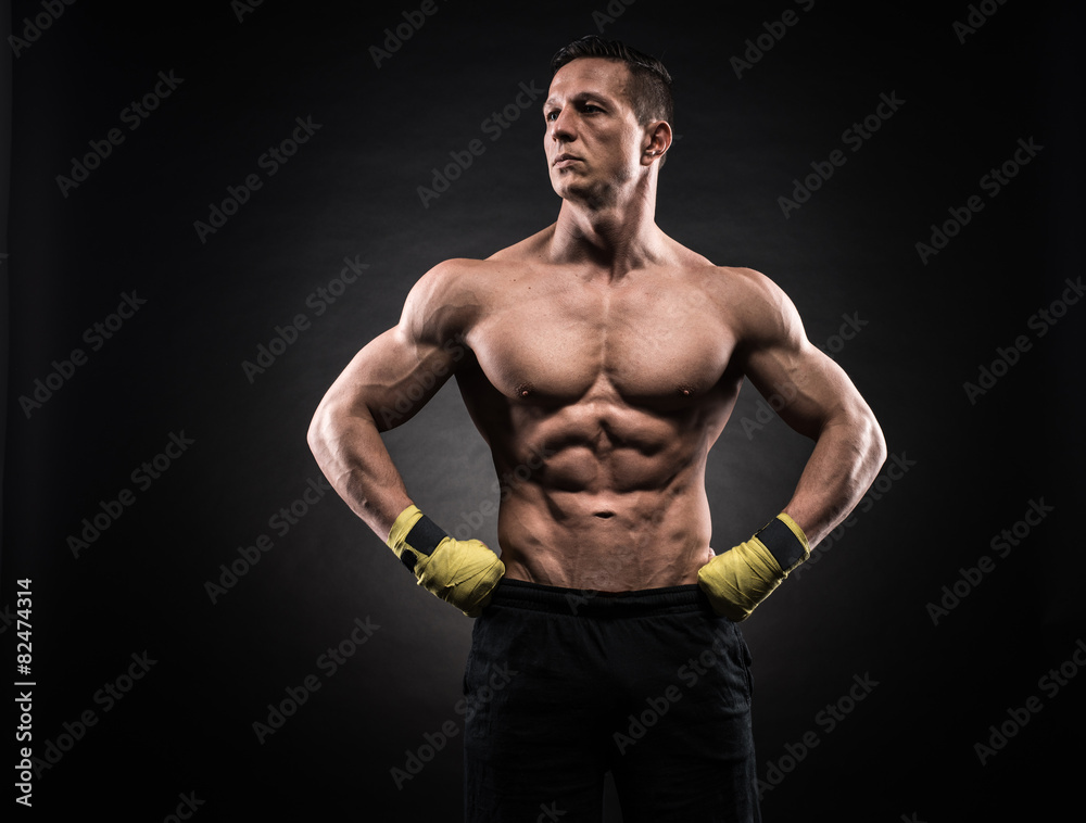 Muscular man in studio on dark background Muscular man in studio on dark background