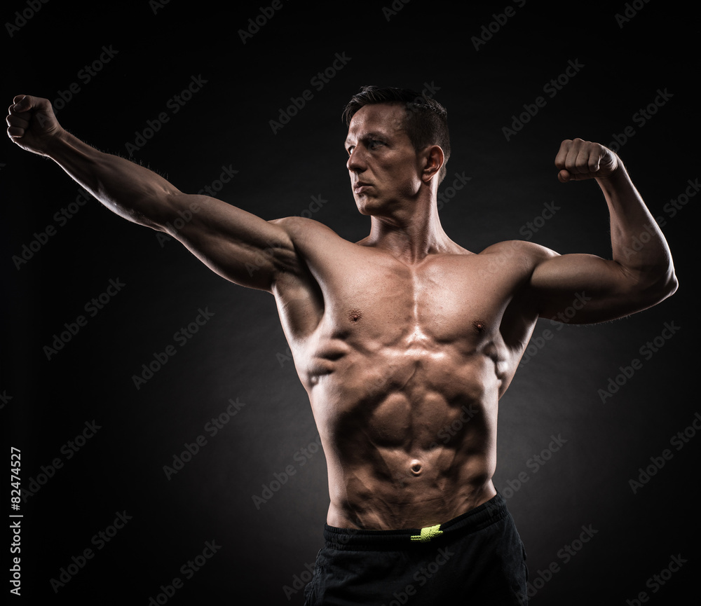 Muscular man in studio on dark background Muscular man in studio on dark background