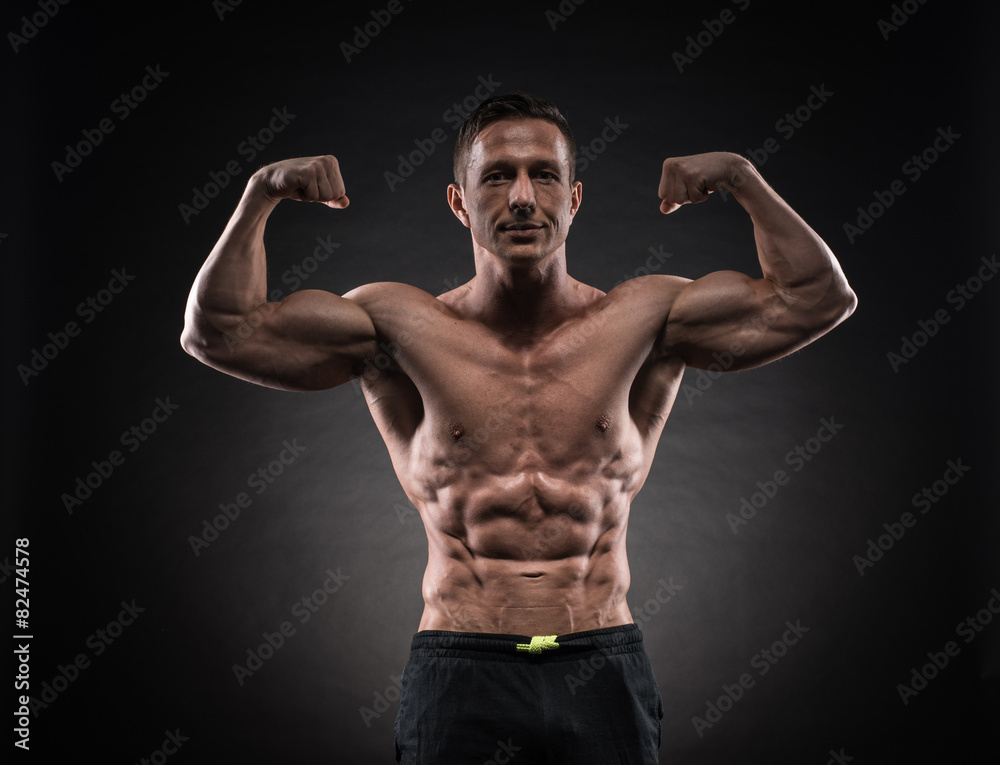 Muscular man in studio on dark background