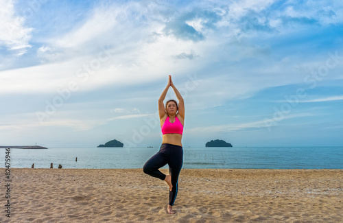 Fat Thai woman poses a standing asana yoga or vriksasana