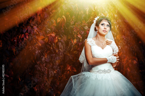 portrait of beautiful young bride holding bright bouquet in