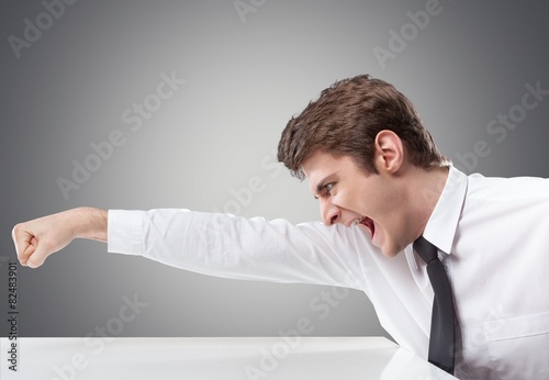 Anger. Furious businessman throws a punch into the computer