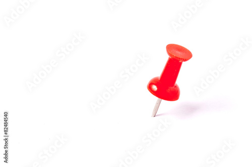 close up of a red pushpin on white background