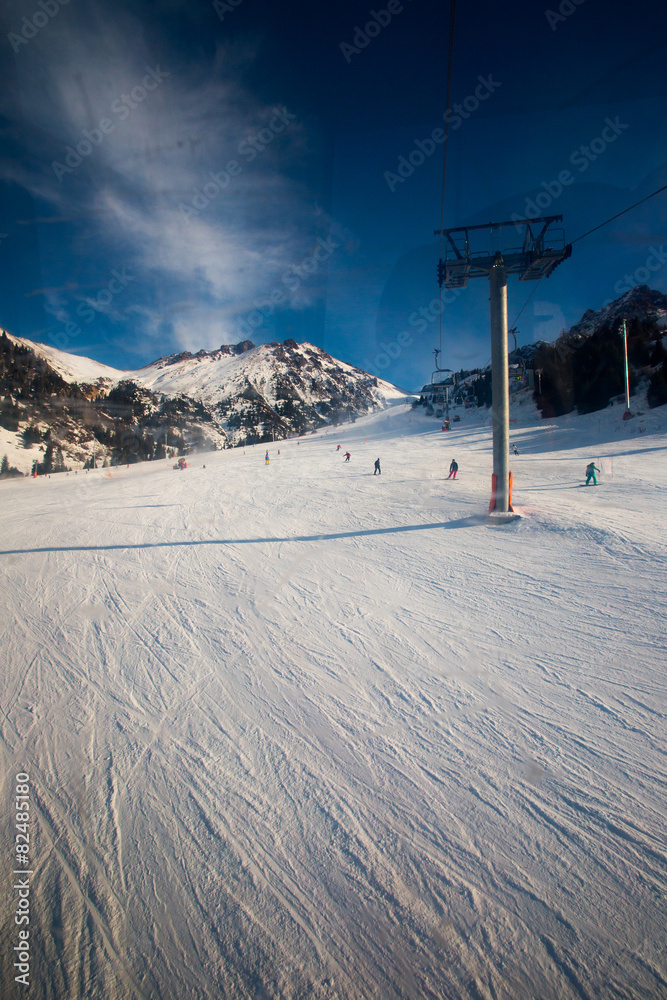 Fototapeta premium The cable car in the snowy mountains Chimbulak