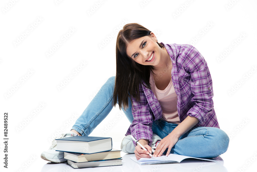 Happy woman sitting on the floor and writing in notebook Happy woman sitting on the floor and writing in notebook