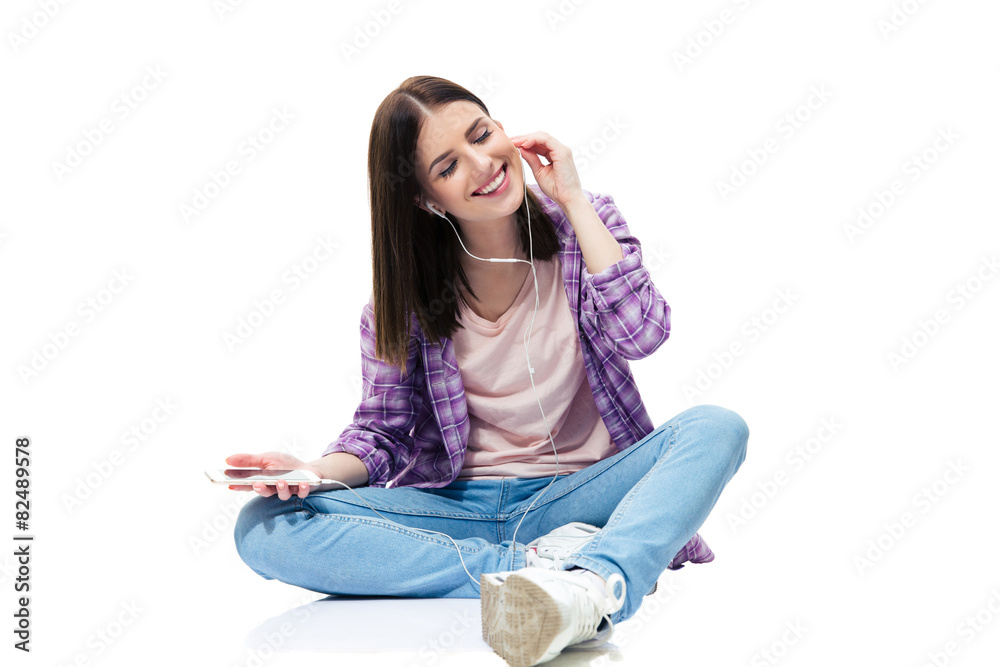 Happy woman sitting on the floor and listening music