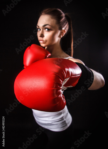 Young woman in a boxing gloves (focus is on the glove)