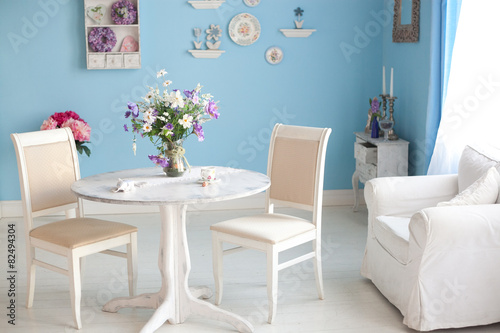dining room interior with flowers decorative plates blue wall an photo