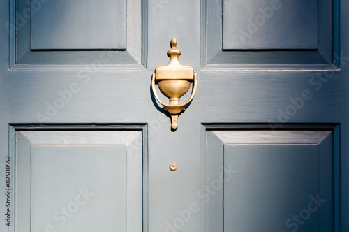 Background of vintage blue painted door and knocker vignette