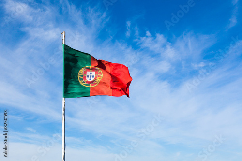 Portugal flag waving on the wind over a cloudy blue sky