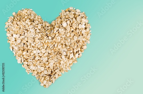 Oat. Heap of oat flakes in a shape of heart shot from above
