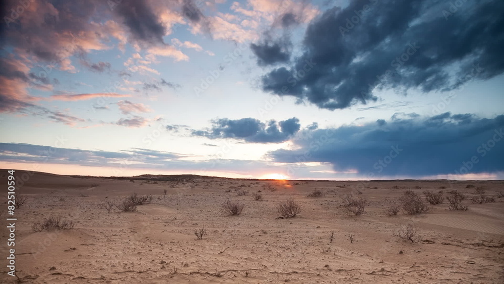Clouds float over the desert at sunset. Timelapse
