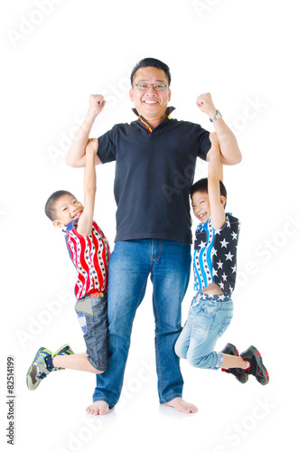 Asian man lifting up his twin sons