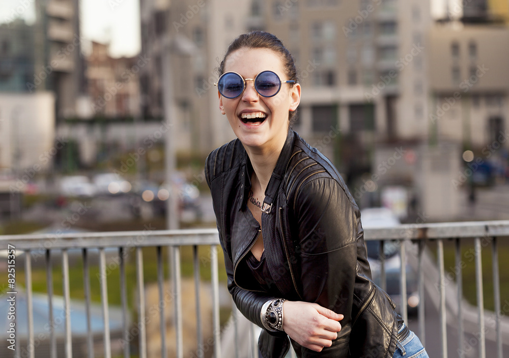 Girl with sunglasses laughing in the city