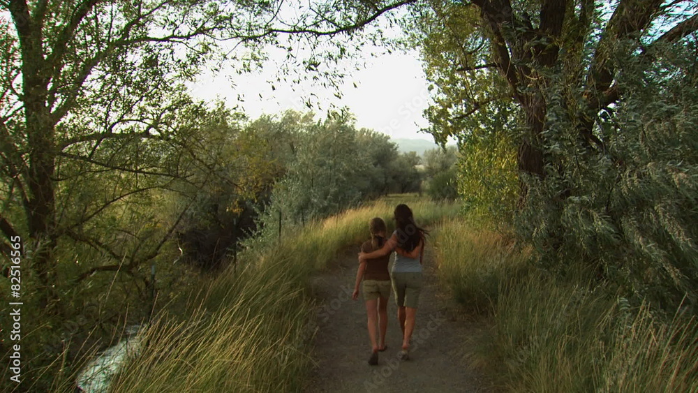 mother and daughter walking down a trail mother and daughter walking down a trail