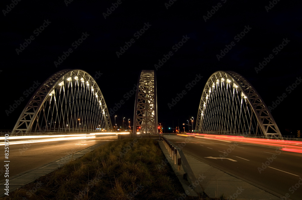 Fototapeta premium Street View of Cars Crossing a Bridge at Night