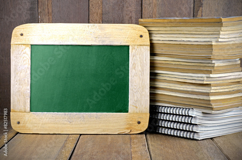 Stack of Old Books and Blackboard on Wood Background in Oldies E