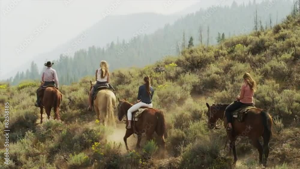 Panning medium shot of friends horseback riding / Idaho, United States