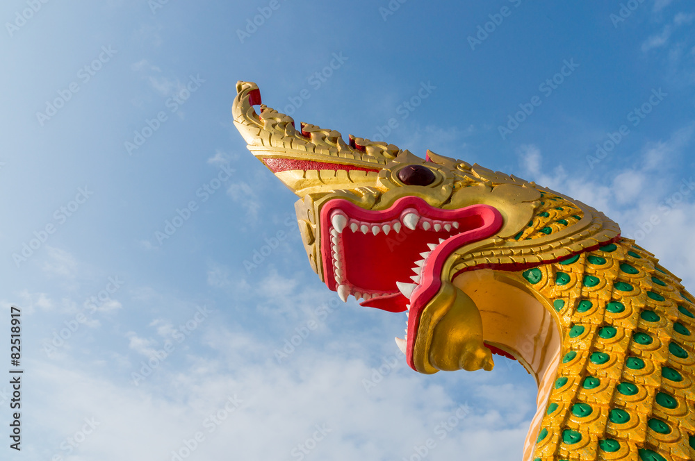 Naklejka premium serpent king or king of naga statue in thai temple on blue sky b