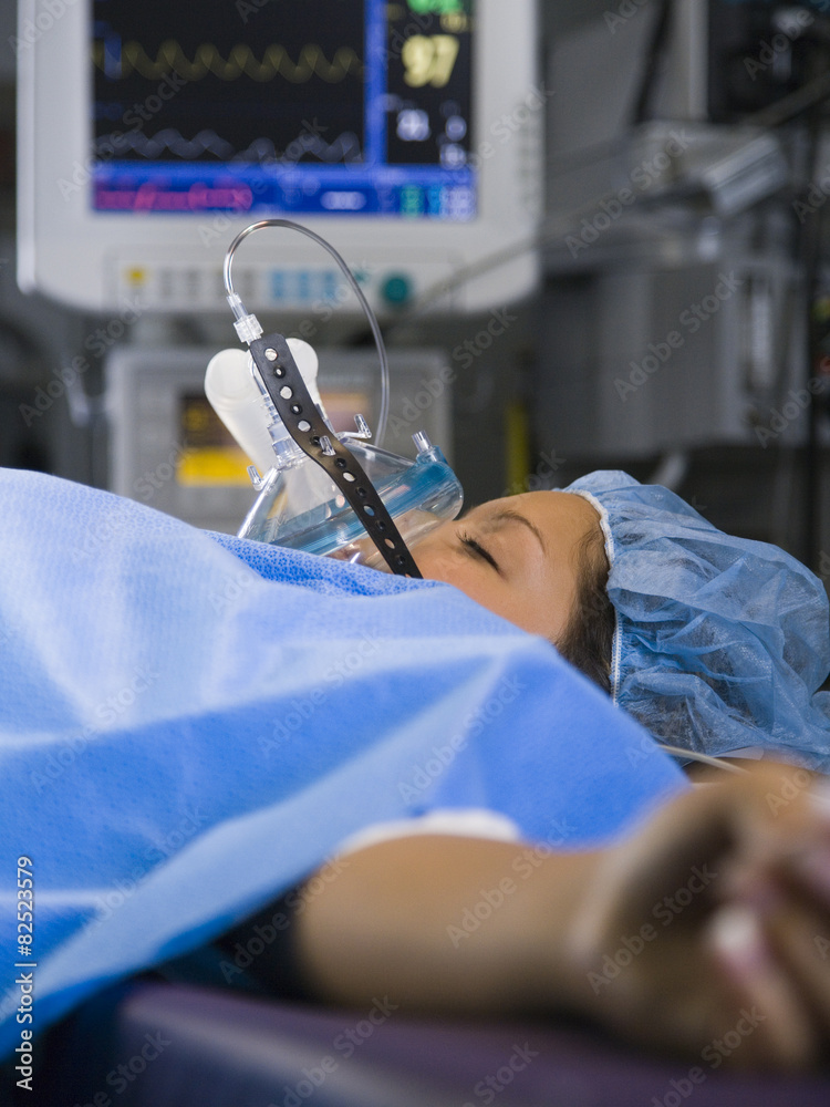 Woman with oxygen mask lying on bed in the operating room Stock Photo |  Adobe Stock
