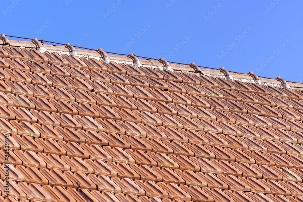 old roof of orange clay tiles with blue sky