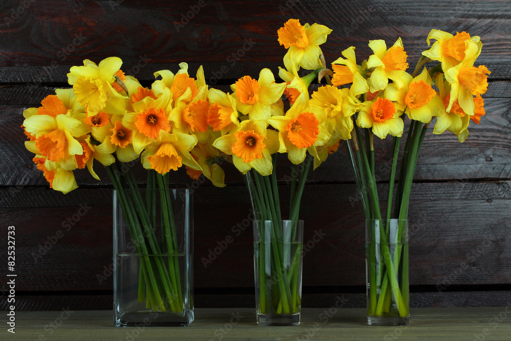 Fototapeta premium Daffodils in a bottle on a wooden background
