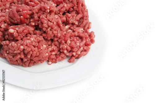 carne macinata cruda su piatto su sfondo bianco