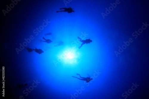 Scuba diving underwater: divers silhouette and sun © Richard Carey
