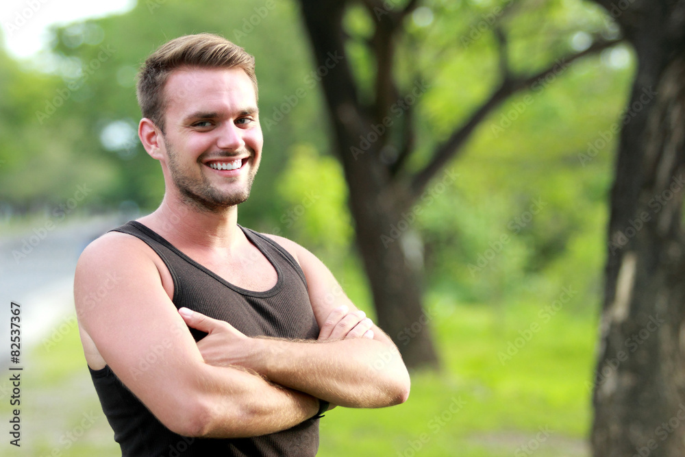 young sporty man smiling and pose with folded arm