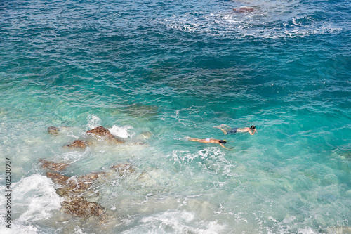 Obraz na plátně Couple snorkeling in turquoise, choppy sea