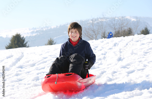 Fotografia child with brown hair in the winter plays with bob in the mounta