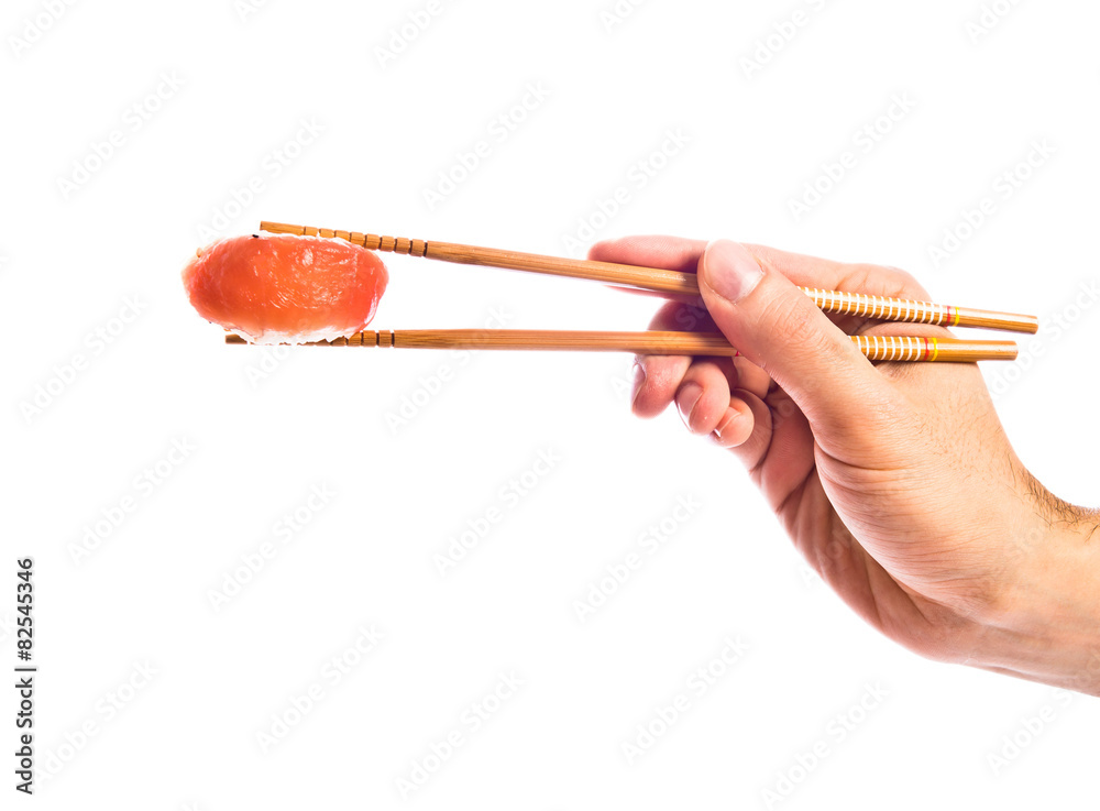 hand holding sushi with chopsticks hand holding sushi with chopsticks