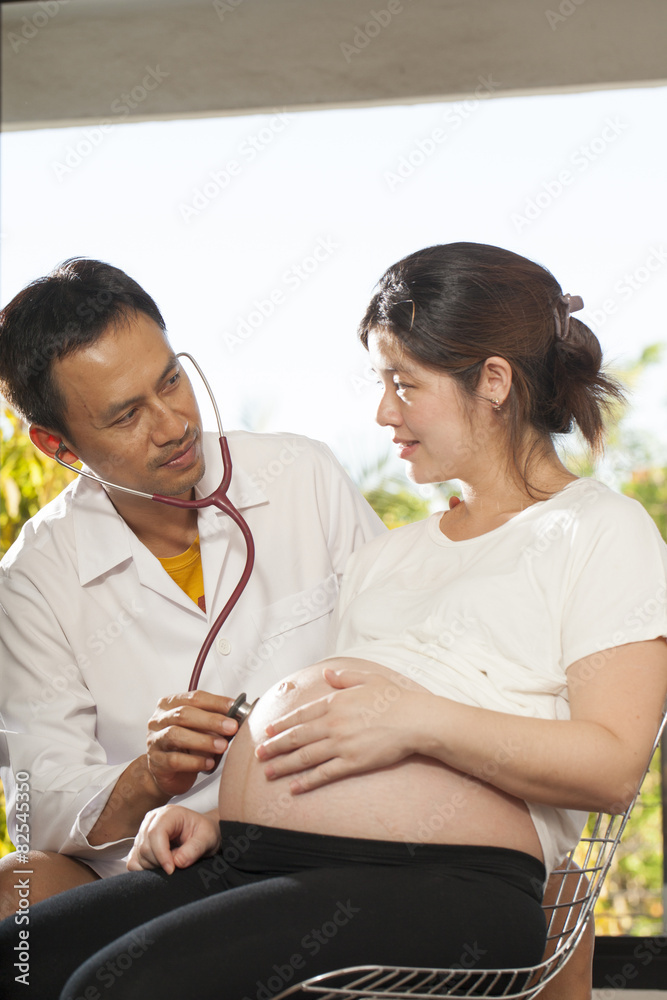 a male doctor using stethoscope check on pregnant woman a male doctor using stethoscope check on pregnant woman