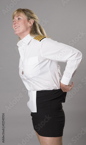 Woman airline officer tucking uniform shirt into her skirt photo