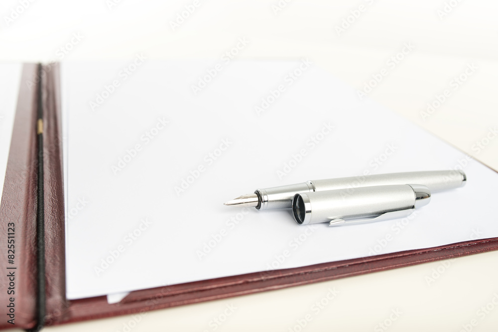 Fountain pen lying on blank paper Fountain pen lying on blank paper