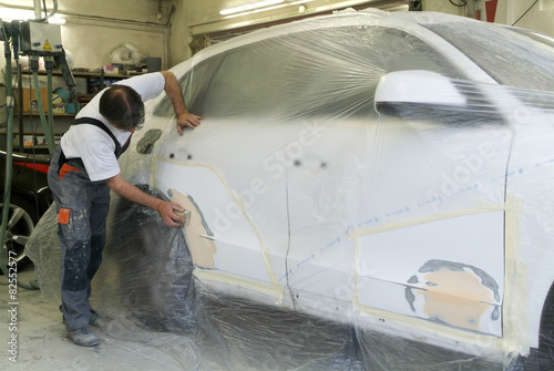 Mechanic reparing a car in auto repair shop photo