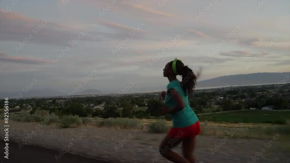 Tracking medium shot of teenage girl running on road / Cedar Hills, Utah, United States Tracking medium shot of teenage girl running on road / Cedar Hills, Utah, United States