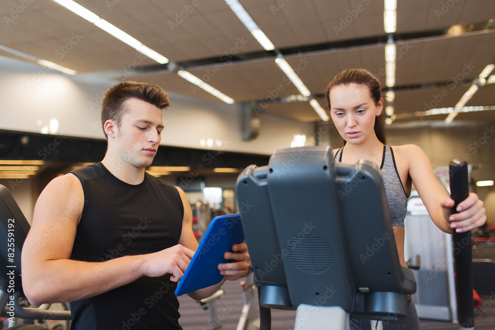 woman with trainer exercising on stepper in gym woman with trainer exercising on stepper in gym