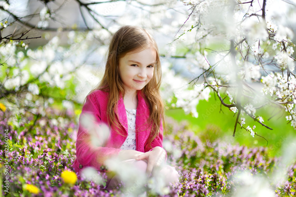 Adorable little girl in blooming cherry garden Adorable little girl in blooming cherry garden