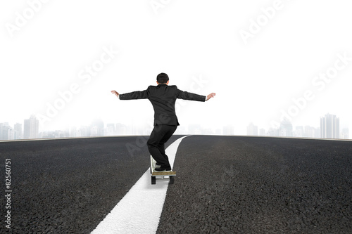 Businessman skateboarding on asphalt road with urban scene
