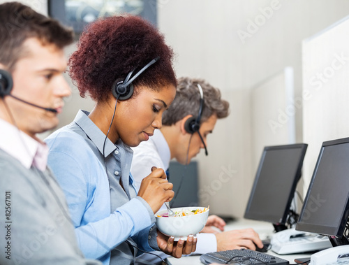 Female Customer Service Representative Having Food In Office