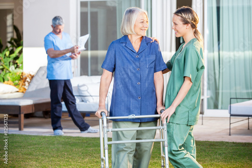 Nurse Assisting Senior Woman To Walk With Zimmer Frame © Tyler Olson
