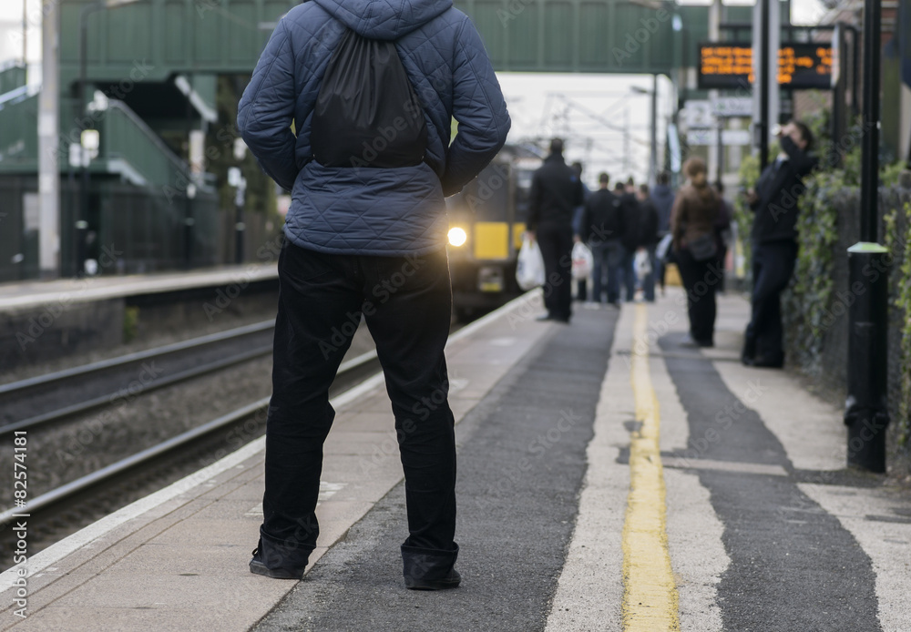 Man standing on station platform as train pulls in Man standing on station platform as train pulls in