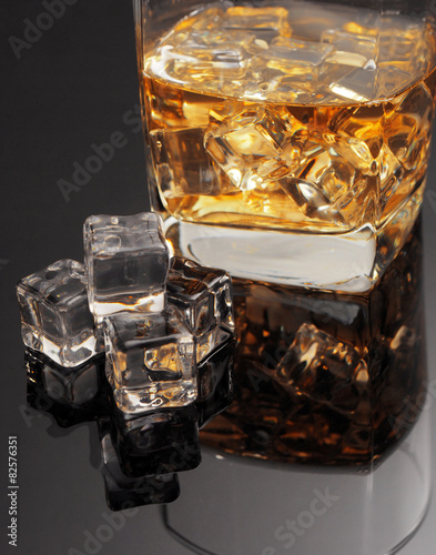 Whiskey and ice cube inglass