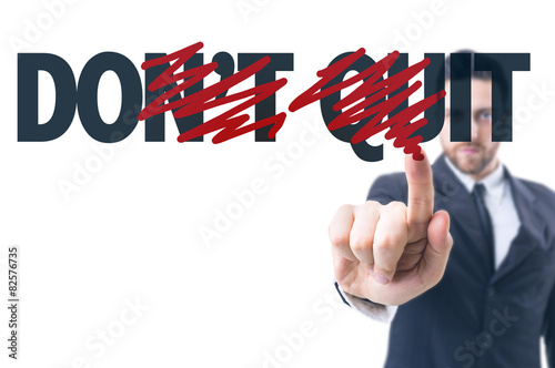Business man pointing the text: Don't Quit