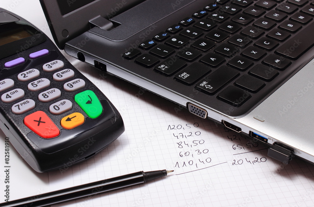 Payment terminal, laptop and financial calculations Payment terminal, laptop and financial calculations