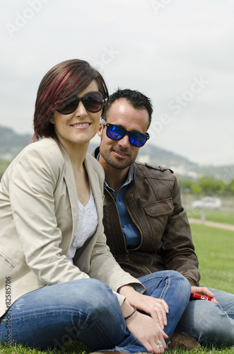 Couple with sunglasses posing at city park