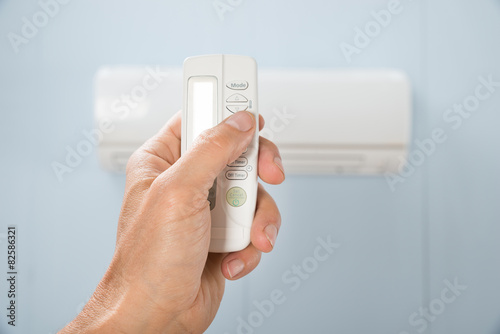 Person Hand Holding Air Conditioner Remote