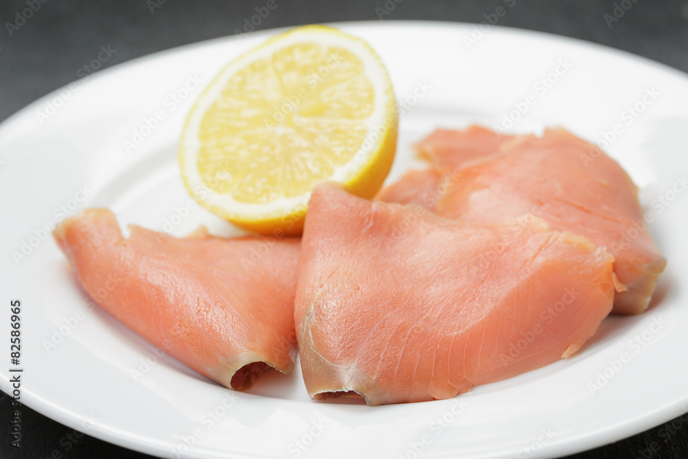 rolls of sliced smoked salmon on slate board