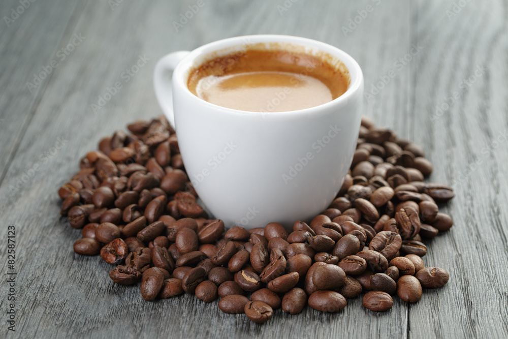 cup of fresh espresso with coffee beans on oak table cup of fresh espresso with coffee beans on oak table
